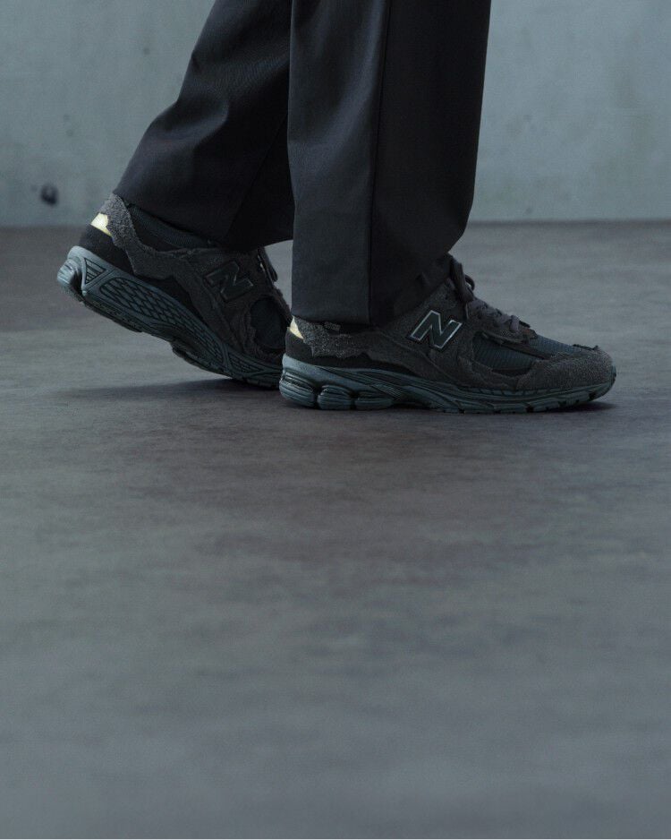 A pair of New Balance sneakers on concrete floor.